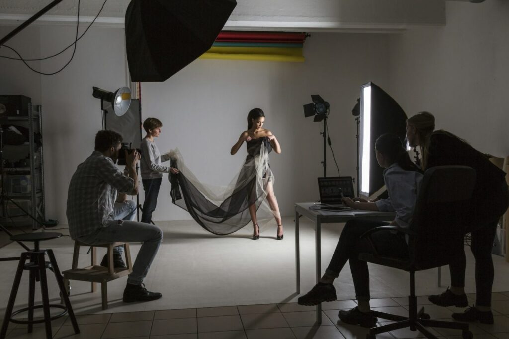 Photography team and model in low key photography studio shoot